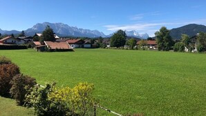 A rural village with houses, a large green field, and mountains in the background. - Apartment '2' with Mountain View, Shared Garden and Wi-Fi (Krün)