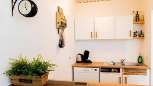A compact kitchen with white cabinets, a wooden countertop, a coffee maker, and a sink. - Central & bright | 4 persons (Magdeburg)