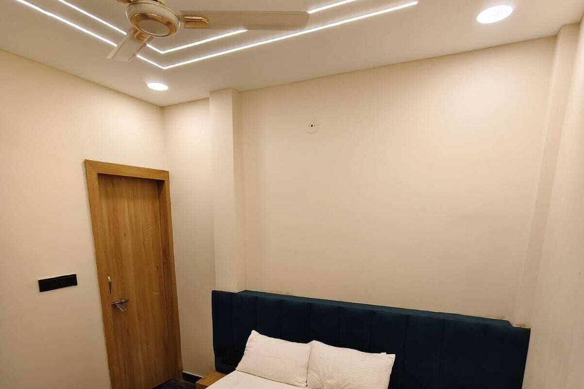 Un dormitorio con cama, una puerta de madera y un ventilador de techo.