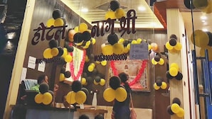 A hotel entrance with a neon sign in a foreign language, balloons, and a partially visible interior. - Hotel Naagshree (Ujjain)