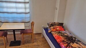 A small room with a bed, a table, and a chair. - Apartment 'Appartement Aurach A6' with Wi-Fi (Aurach)
