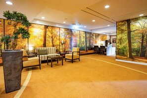 Relax in a warm and inviting lobby with a spacious seating area and vibrant autumn-themed murals.
