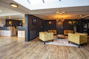 Welcome to our hotel lobby, featuring a high ceiling, reception desk, and comfortable seating area.