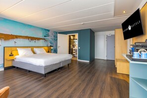 Relax in a serene lakeside-inspired room with a large bed, flat-screen TV, and convenient coffee station.