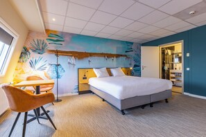 Experience the nautical theme in this stylish room, featuring a large bed, a vibrant seascape mural, and a modern workspace.