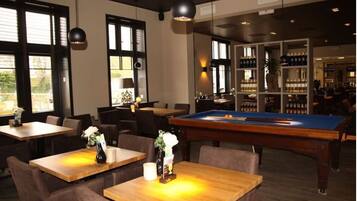 Relax in a spacious room with a pool table, seating areas, and a bar area.