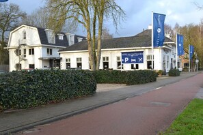 Hotel Het Veldhuis features a traditional pitched roof and white exterior walls.