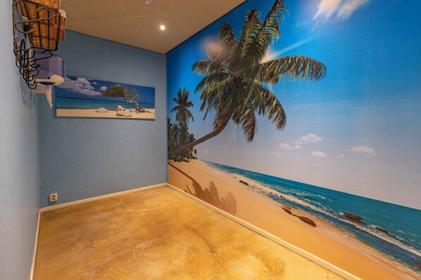 Relax in a beach-inspired retreat with a mural of palm trees and a sandy beach.