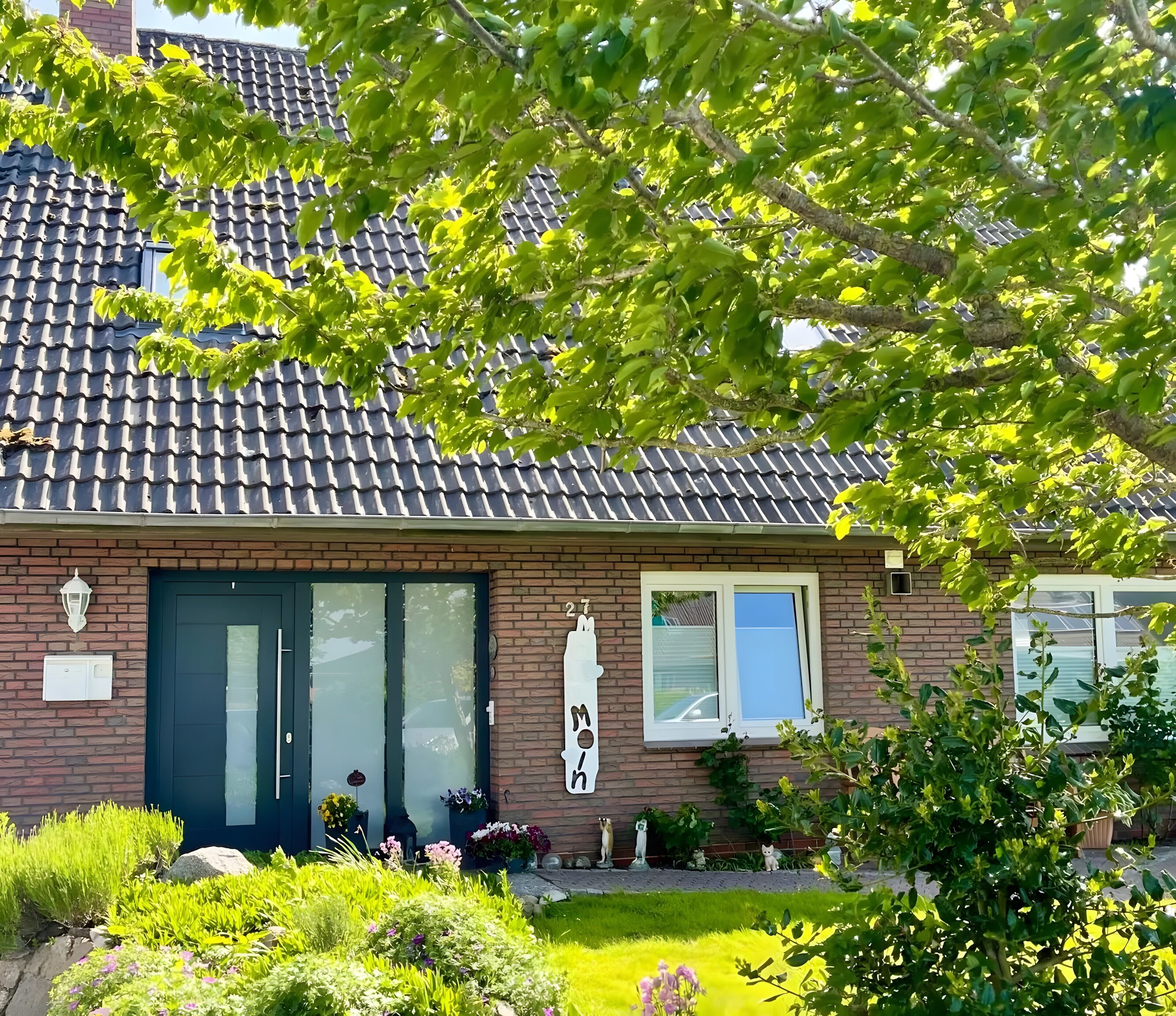 A house with a tiled roof, a brick facade, a dark front door, and a small window.