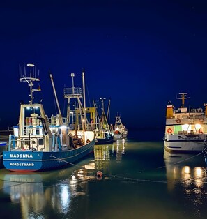 A marina at night with several boats docked, including one named 'MADONNA' and another 'NORSTRAND'. - Apartment 'Nordstrand' with Balcony and Wi-Fi (Nordstrand)