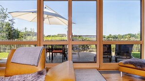 Ein Zimmer mit großen Schiebeg lass-Türen, einem Sofa, einem Sessel und einem Tisch.