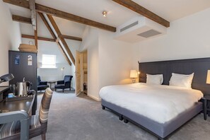Relax in a spacious room with a large bed, desk area, and cozy carpeted floor.