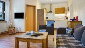 Una sala de estar con un sofá, una mesa y un televisor.