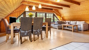 Une pièce confortable de style loft, comprenant un coin repas, un espace salon et une grande fenêtre.