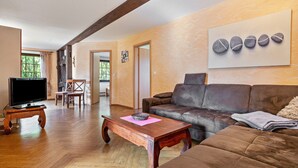 Una sala de estar con televisión, sofá, mesa de centro y chimenea.