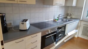 Een koelkast, een oven, een kookplaat, een vaatwasser