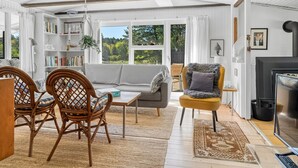 A spacious living room with a sofa, chairs, a fireplace, and a bookshelf. - "Rieke" - 2km from the sea by Interhome (Blokhus)