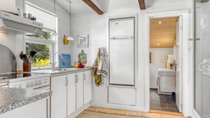 A modern kitchen with white cabinetry, a built-in stove, and a large window. - "Rieke" - 2km from the sea by Interhome (Blokhus)
