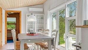 A dining area with a table, chairs, and a view of greenery outside. - "Rieke" - 2km from the sea by Interhome (Blokhus)