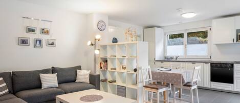 A modern living room with a sofa, coffee table, and bookshelves.