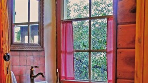 A bathroom with a sink, mirror, and window with red curtains. - Holiday Home 'Bernau' with Mountain View, Private Terrace and Wi-Fi (Bernau im Schwarzwald)