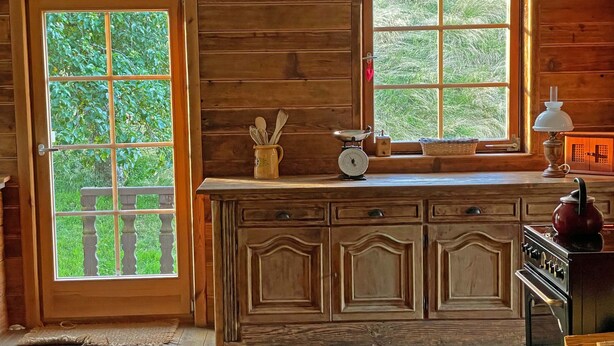 A wooden cabin interior with a kitchen counter, a scale, a kettle, and a basket of firewood. - Holiday Home 'Bernau' with Mountain View, Private Terrace and Wi-Fi (Bernau im Schwarzwald)