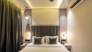A modern hotel room with a large bed, two bedside tables with lamps, a headboard, and a large window. - Hotel Windsor Castle (Mumbai)
