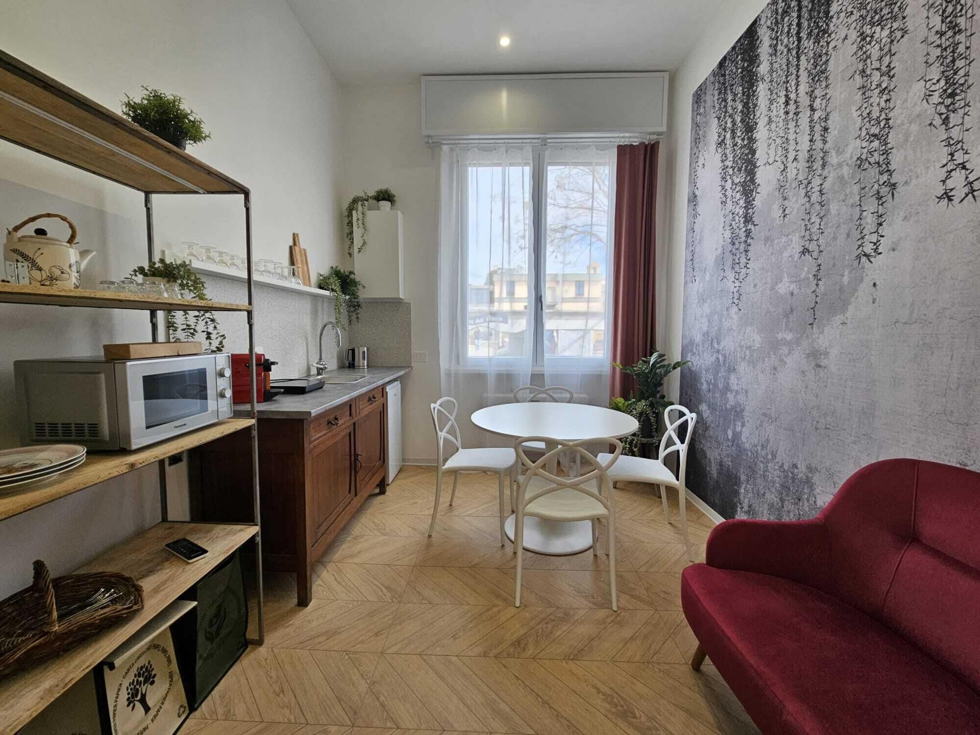 A compact living space with a kitchen, dining area, and a red sofa.