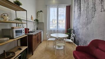 A compact living space with a kitchen, dining area, and a red sofa.