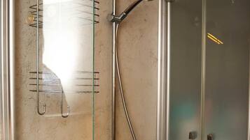 Une salle de bain moderne avec une douche à parois de verre, un porte-serviettes et un meuble-lavabo en bois.