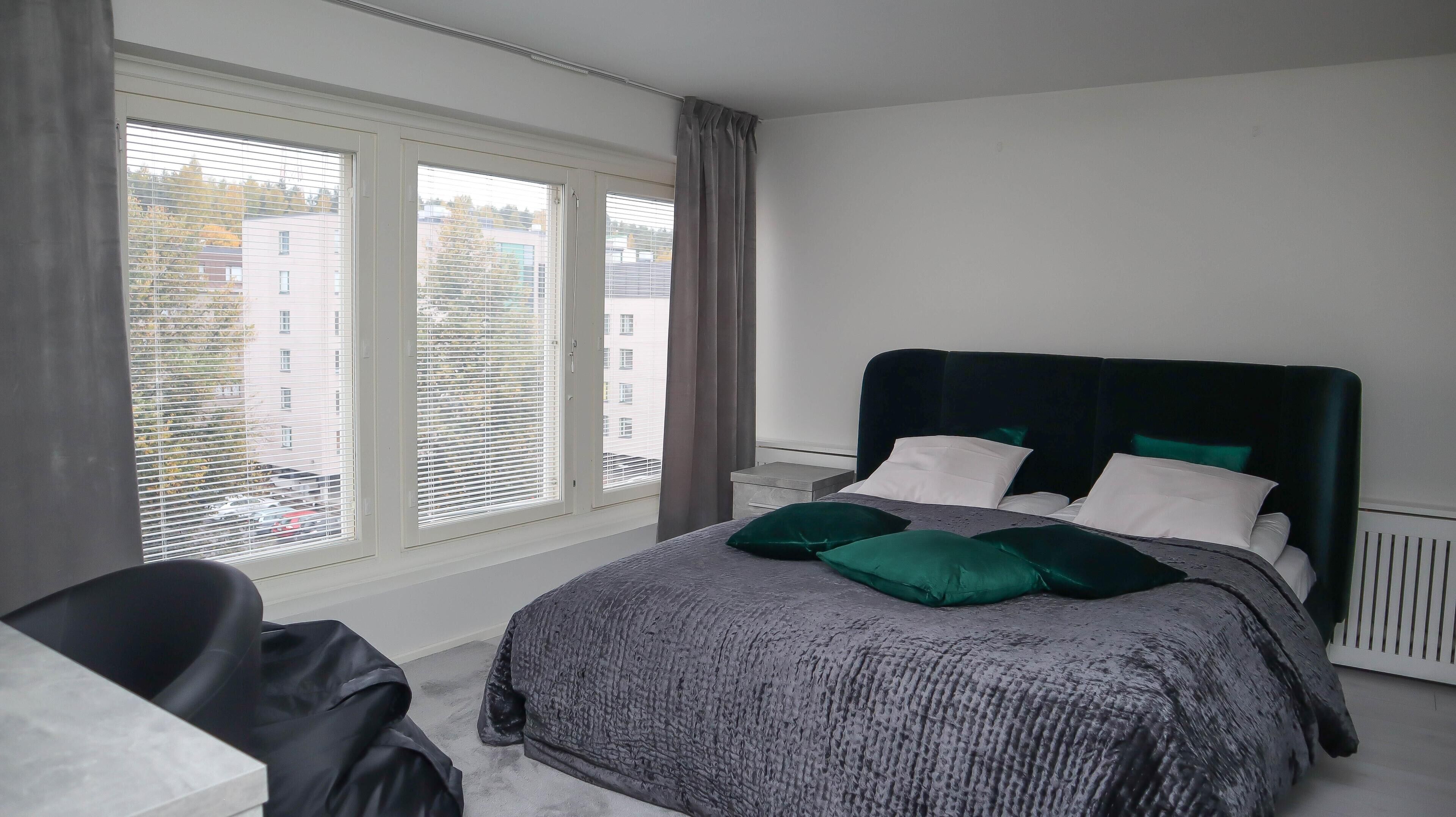 Une chambre à coucher avec un lit, une chaise et une fenêtre équipée de stores.