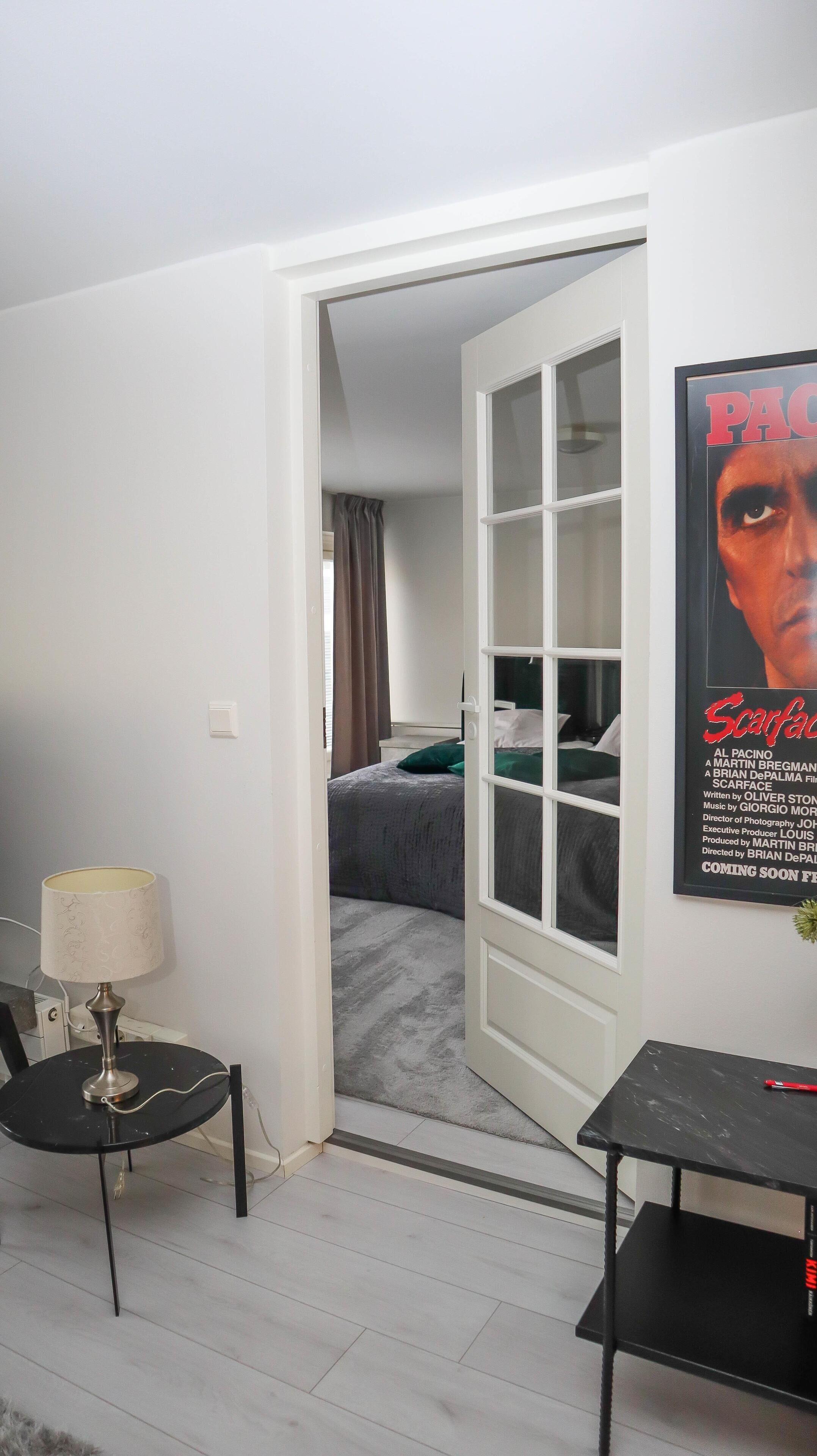 Una habitación con cama, escritorio, silla y un cartel en la pared.