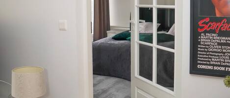 Una habitación con cama, escritorio, silla y un cartel en la pared.