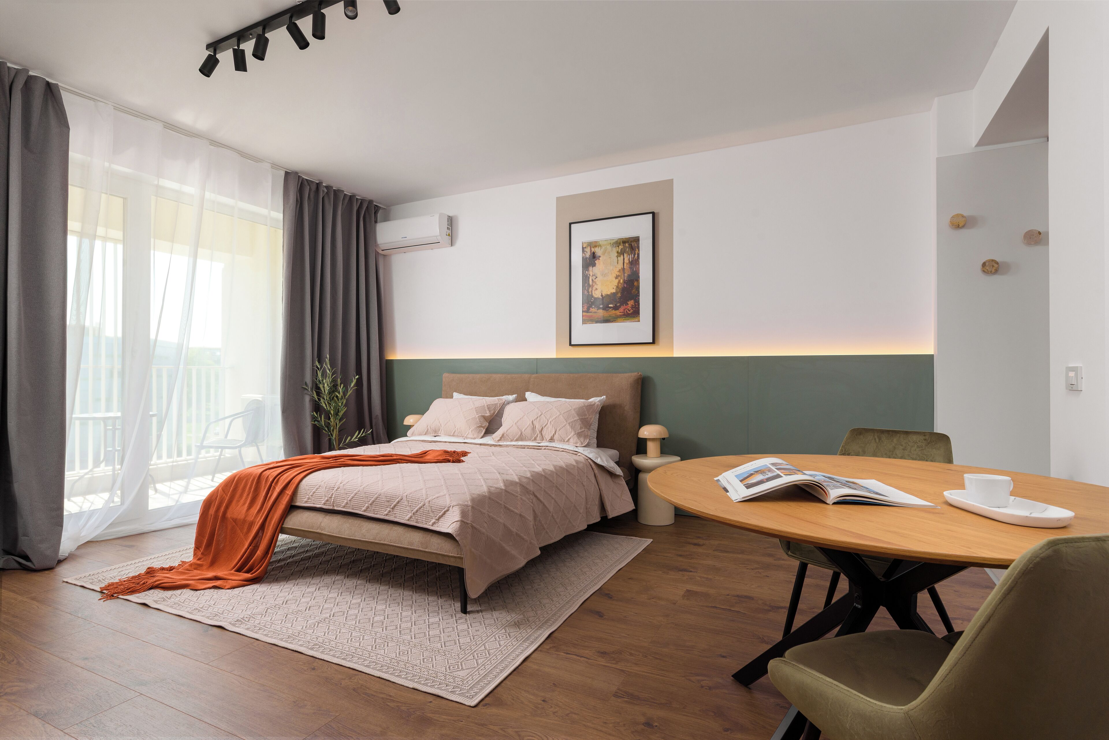 Un hotel moderno con cama, una mesa de comedor y vistas al exterior.