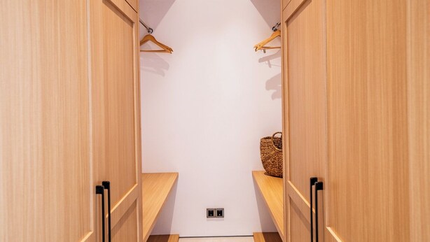 A narrow hallway with wooden cabinets and a small shelf with a basket. - Elements A5 Villa Bingin (Pecatu)
