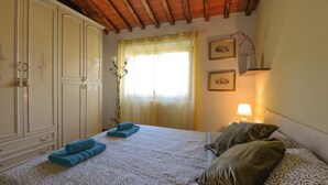 Ein Schlafzimmer mit einem Bett, einem Kleiderschrank und einem Nachttisch mit Lampe.