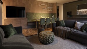 Una sala moderna con sofá, reposapiés y comedor.