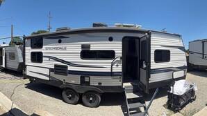 A large RV with a sliding door, a kitchenette, and a small window. - Toy Hauler Vengence Rouge (Brentwood)