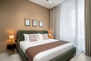 Een moderne hotelkamer met een groot bed, een groen hoofdeinde en een stadsgezicht door dunne gordijnen.