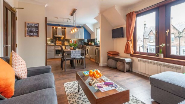 Un appartement moderne comprenant un coin repas, une cuisine et un salon.
