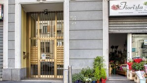 Une devanture de magasin avec une grille métallique et une enseigne indiquant qu’il s’agit d’une boutique de fleurs.