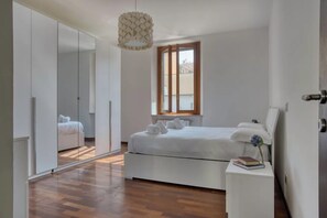 Relax in a serene bedroom with a large bed, bedside table, and mirror.