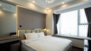 Ein modernes Hotelzimmer mit einem großen Bett, einem Nachttisch, einem Spiegel und einem Fenster mit Vorhängen.