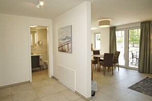 A modern interior with a dining area, a kitchen, and a view to the outside.