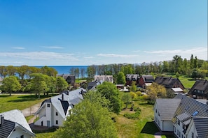 A residential area with houses, green lawns, and a view of the sea. - Beachfront vacation rental with a terrace, access to the pool and sauna - Rex Rugia - Rex (Göhren)