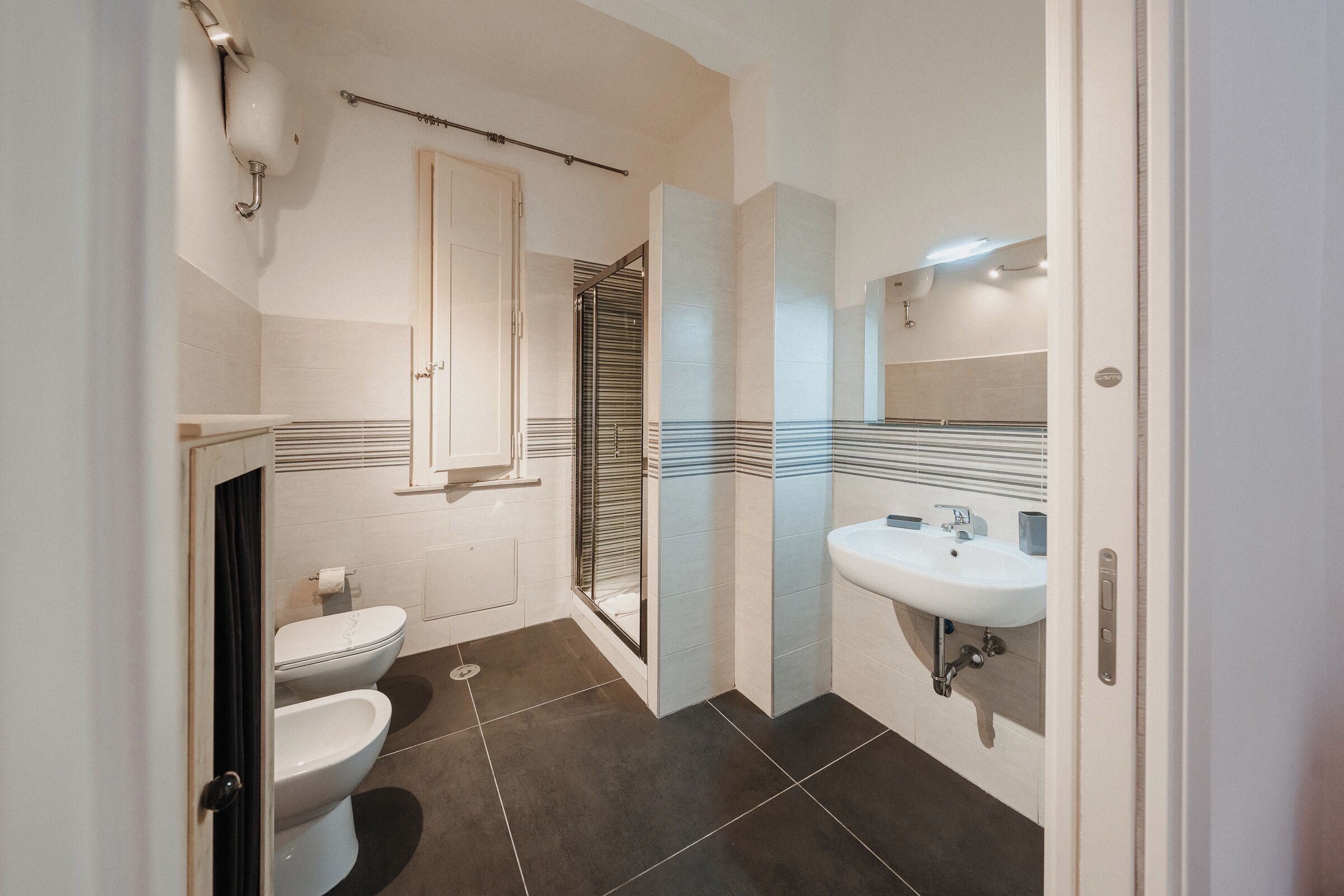 Ein modernes Badezimmer mit Toilette, Bidet und Waschbecken.