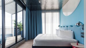 Une chambre à coucher moderne, dotée d’un grand lit, offrant une vue sur l’extérieur et présentant un design de plafond original.