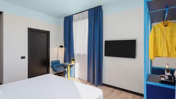 A modern hotel room with a bed, a desk, a chair, a TV, and a wardrobe with a yellow jacket hanging.