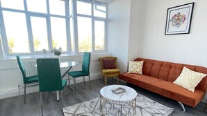 Een moderne woonkamer met een bank, stoelen, een salontafel en een raam met uitzicht.