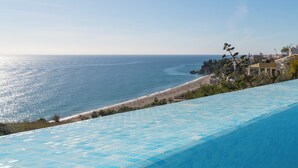 Ein Hotel an der Küste mit Pool und Blick auf Strand und Meer.